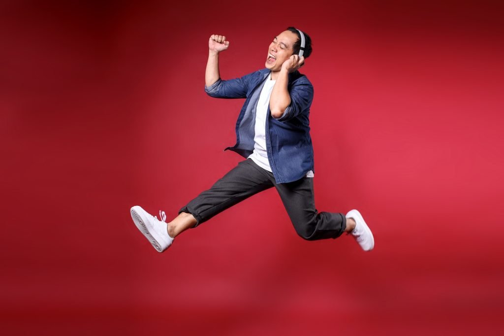 man jumping while listening to music