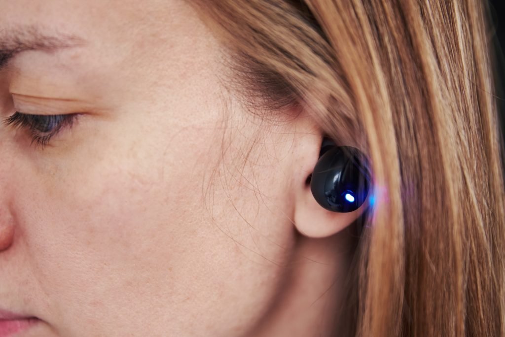 Woman listening music through wireless earphones